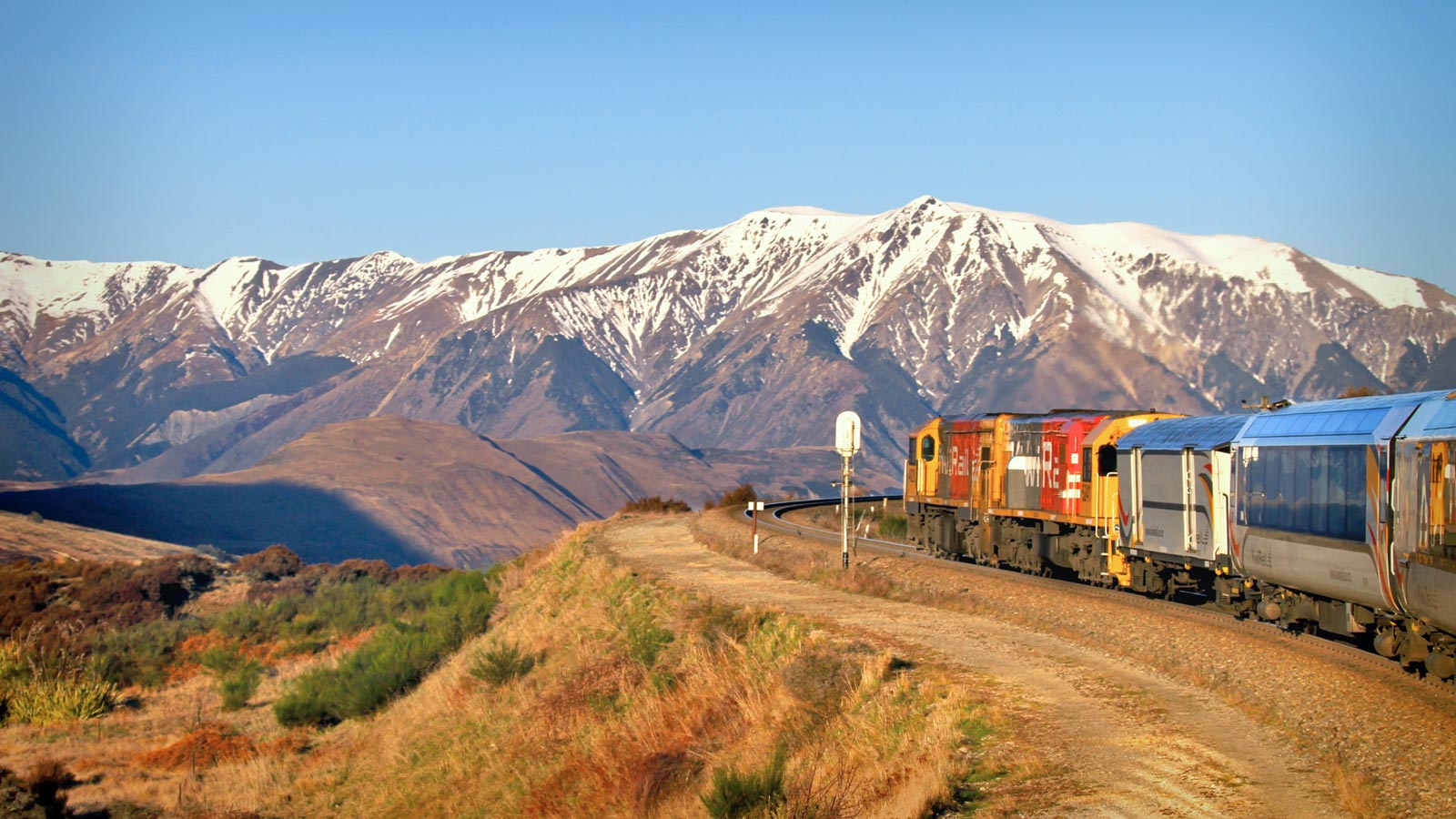 TranzAlpine train rounding Cass Bank beneath the snow-dusted Southern Alps